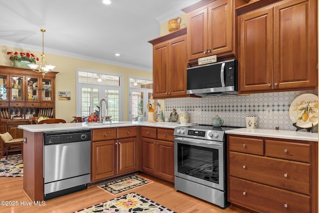 155 Mckenzie Rd E, Pinehurst, NC 28374 - kitchen featuring stainless steel appliances, a peninsula, a sink, light wood-style flooring, and light countertops