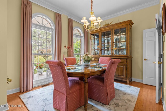155 Mckenzie Rd E, Pinehurst, NC 28374 - dining space with a chandelier, ornamental molding, light wood-type flooring, and baseboards