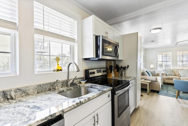 805 Carolina Beach Ave N, Carolina Beach, NC 28428 - kitchen featuring stainless steel appliances, a sink, light wood finished floors, ornamental molding, and light stone countertops