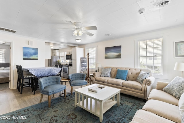 805 Carolina Beach Ave N, Carolina Beach, NC 28428 - living area featuring healthy amount of natural light, wood finished floors, a ceiling fan, and crown molding