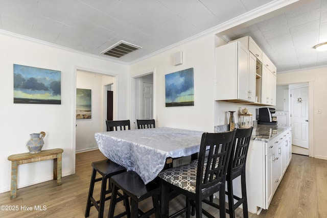 805 Carolina Beach Ave N, Carolina Beach, NC 28428 - dining space featuring crown molding, wood finished floors, and baseboards