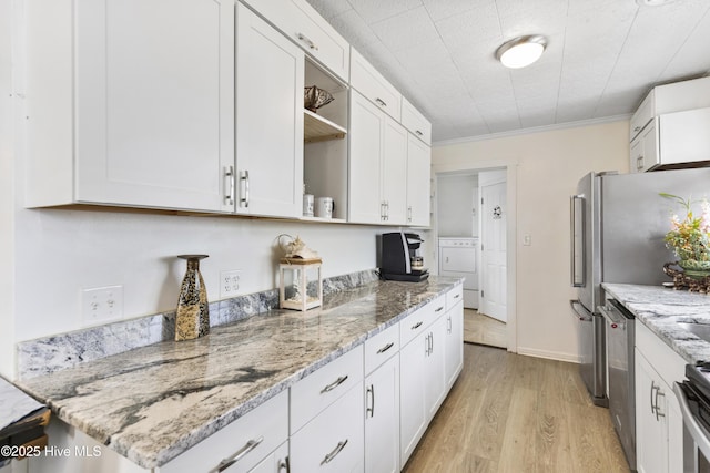 805 Carolina Beach Ave N, Carolina Beach, NC 28428 - kitchen with open shelves, washer / clothes dryer, appliances with stainless steel finishes, white cabinetry, and light wood finished floors