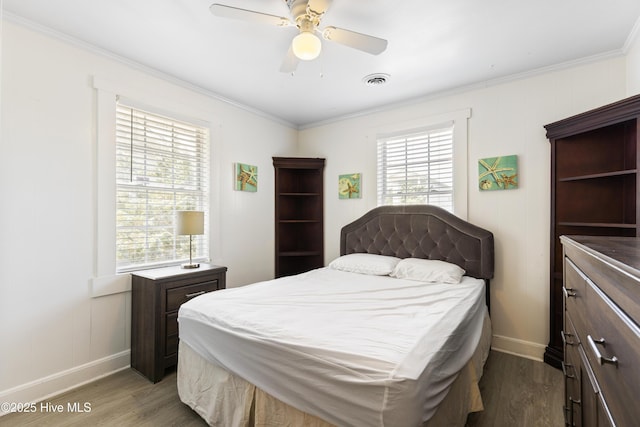 805 Carolina Beach Ave N, Carolina Beach, NC 28428 - bedroom with wood finished floors, ornamental molding, baseboards, a ceiling fan, and a decorative wall