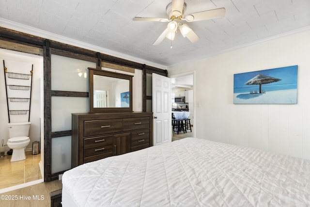 805 Carolina Beach Ave N, Carolina Beach, NC 28428 - bedroom with a barn door, crown molding, wood finished floors, ensuite bathroom, and a ceiling fan