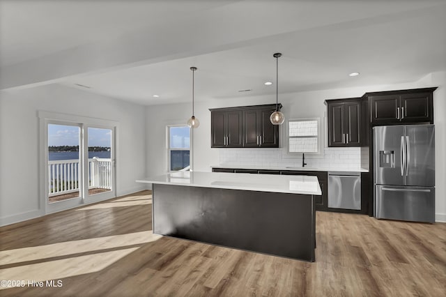 232 Shell Dr, Sneads Ferry, NC 28460 - kitchen featuring appliances with stainless steel finishes, a sink, light countertops, a center island, and light wood-style floors