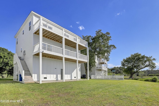 232 Shell Dr, Sneads Ferry, NC 28460 - back of property with board and batten siding, a yard, and stairway