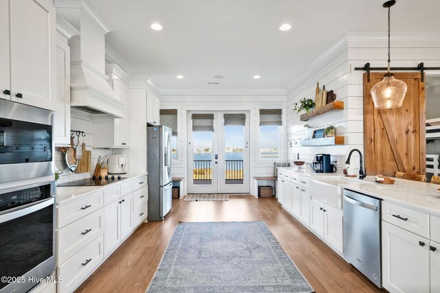 1753 New River Inlet Rd, North Topsail Beach, NC 28460 - kitchen featuring appliances with stainless steel finishes, custom range hood, wood finished floors, white cabinets, and recessed lighting