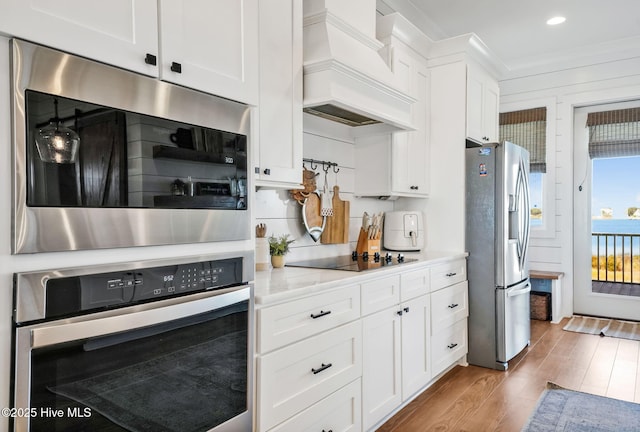 1753 New River Inlet Rd, North Topsail Beach, NC 28460 - kitchen featuring stainless steel appliances, custom exhaust hood, wood finished floors, white cabinetry, and recessed lighting