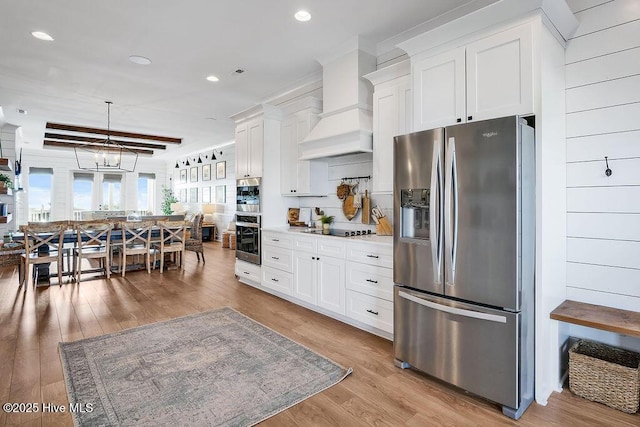 1753 New River Inlet Rd, North Topsail Beach, NC 28460 - kitchen featuring stainless steel appliances, white cabinets, light wood-style floors, custom exhaust hood, and recessed lighting