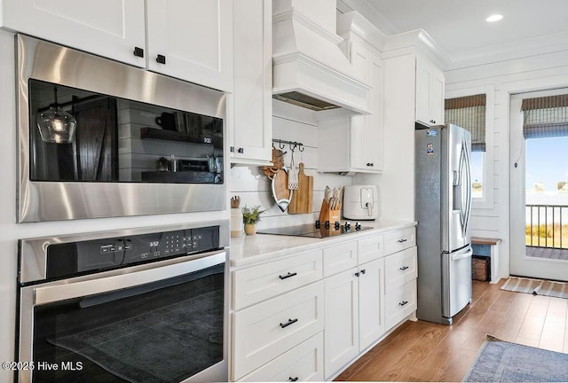 1753 New River Inlet Rd, North Topsail Beach, NC 28460 - kitchen featuring appliances with stainless steel finishes, premium range hood, wood finished floors, white cabinets, and recessed lighting