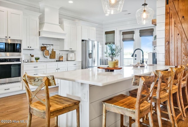 1753 New River Inlet Rd, North Topsail Beach, NC 28460 - kitchen featuring appliances with stainless steel finishes, custom exhaust hood, a kitchen breakfast bar, a sink, and light countertops