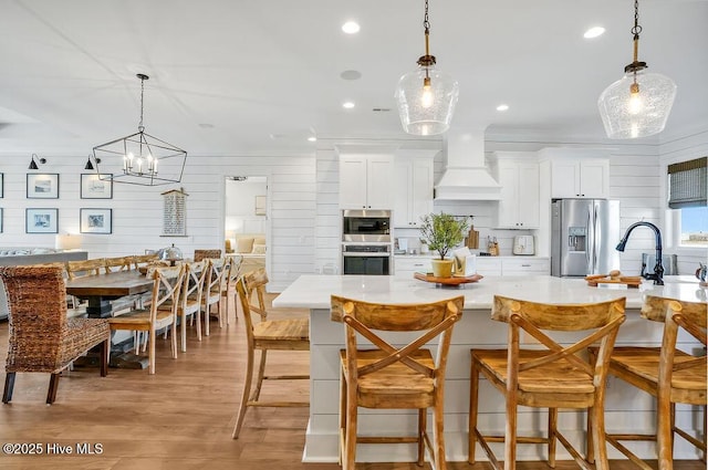 1753 New River Inlet Rd, North Topsail Beach, NC 28460 - kitchen with stainless steel appliances, premium range hood, light countertops, a sink, and recessed lighting