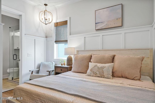 1753 New River Inlet Rd, North Topsail Beach, NC 28460 - bedroom with a decorative wall, a chandelier, wood finished floors, wainscoting, and crown molding