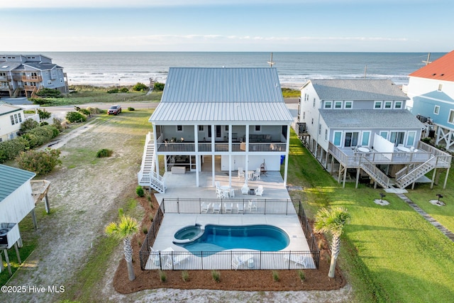 1753 New River Inlet Rd, North Topsail Beach, NC 28460 - rear view of property with stairway, a water view, metal roof, a pool with connected hot tub, and a balcony
