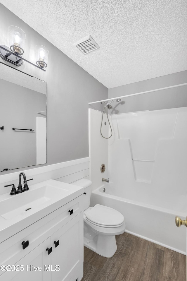 422 Point View Ct, Wilmington, NC 28411 - bathroom with wood finished floors, toilet, vanity, a textured ceiling, and shower / bathtub combination