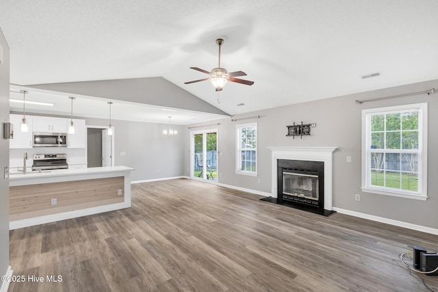 422 Point View Ct, Wilmington, NC 28411 - unfurnished living room featuring ceiling fan, a glass covered fireplace, lofted ceiling, wood finished floors, and a sink