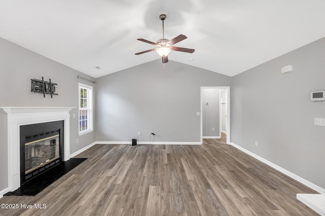 422 Point View Ct, Wilmington, NC 28411 - unfurnished living room with a ceiling fan, wood finished floors, vaulted ceiling, a glass covered fireplace, and baseboards