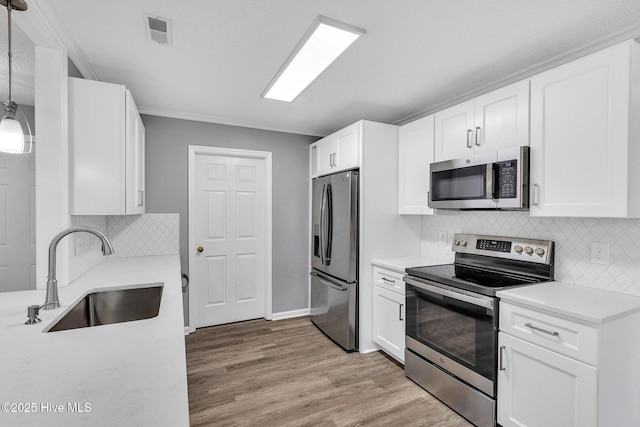 422 Point View Ct, Wilmington, NC 28411 - kitchen with stainless steel appliances, a sink, white cabinetry, light countertops, and ornamental molding