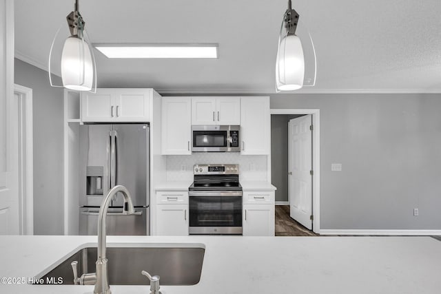 422 Point View Ct, Wilmington, NC 28411 - kitchen featuring appliances with stainless steel finishes, ornamental molding, white cabinets, and light countertops