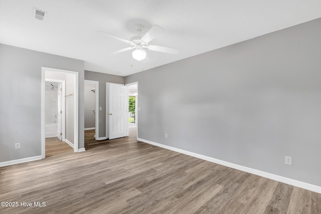 422 Point View Ct, Wilmington, NC 28411 - unfurnished bedroom with baseboards, wood finished floors, a walk in closet, and ensuite bathroom