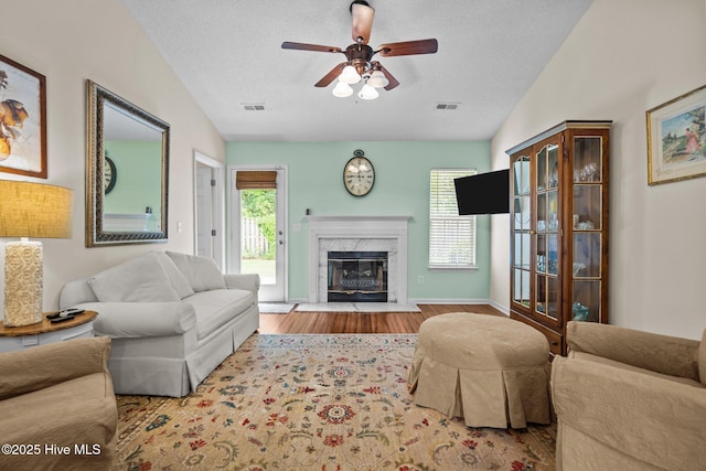 7100 Farrington Farms Dr, Wilmington, NC 28411 - living room featuring a ceiling fan, a premium fireplace, wood finished floors, healthy amount of natural light, and a textured ceiling