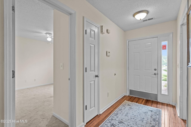 7100 Farrington Farms Dr, Wilmington, NC 28411 - entryway featuring a textured ceiling, baseboards, a ceiling fan, and wood finished floors