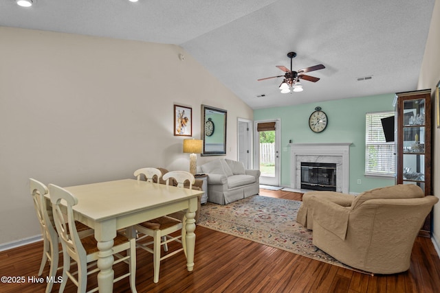 7100 Farrington Farms Dr, Wilmington, NC 28411 - living room with vaulted ceiling, dark wood-style floors, ceiling fan, a high end fireplace, and a textured ceiling