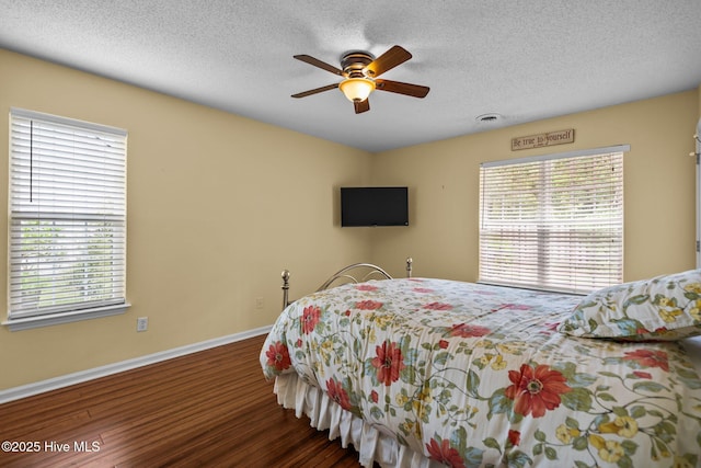 7100 Farrington Farms Dr, Wilmington, NC 28411 - bedroom featuring baseboards, multiple windows, wood finished floors, and a textured ceiling