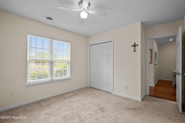 7100 Farrington Farms Dr, Wilmington, NC 28411 - unfurnished bedroom with carpet, baseboards, a closet, a textured ceiling, and a ceiling fan