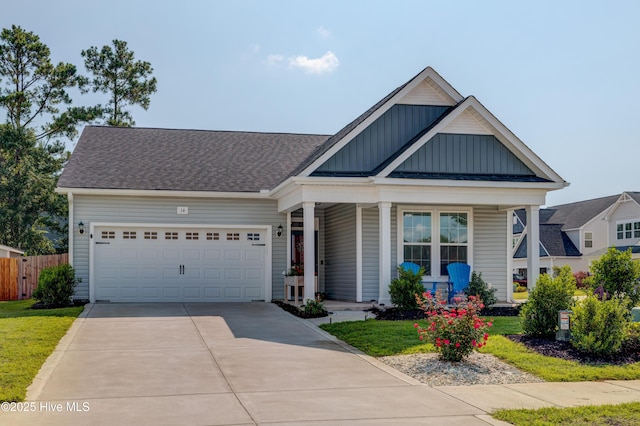 14 Thrush Trl, Hampstead, NC 28443 - view of front of property with board and batten siding, concrete driveway, a garage, covered porch, and a shingled roof