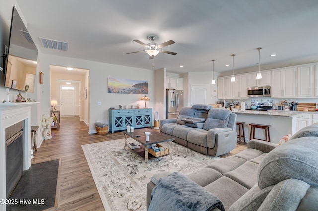 14 Thrush Trl, Hampstead, NC 28443 - living area with a ceiling fan, light wood-style flooring, recessed lighting, baseboards, and a fireplace with flush hearth