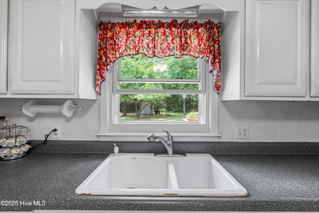 525 Mohican Trl, Wilmington, NC 28409 - kitchen with a sink, dark countertops, and white cabinets