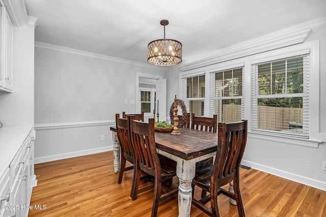 3504 Sheffield Dr, Rocky Mount, NC 27803 - dining area with a chandelier, light wood finished floors, baseboards, crown molding, and a wainscoted wall