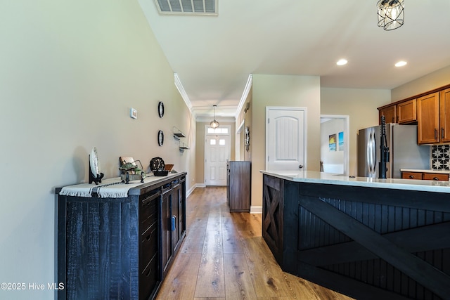 1187 S Brook Rd, Winnabow, NC 28479 - kitchen featuring stainless steel fridge, brown cabinets, light wood-type flooring, recessed lighting, and light countertops