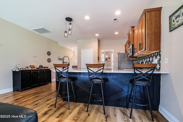 1187 S Brook Rd, Winnabow, NC 28479 - kitchen with brown cabinets, stainless steel appliances, light wood-style floors, light countertops, and recessed lighting
