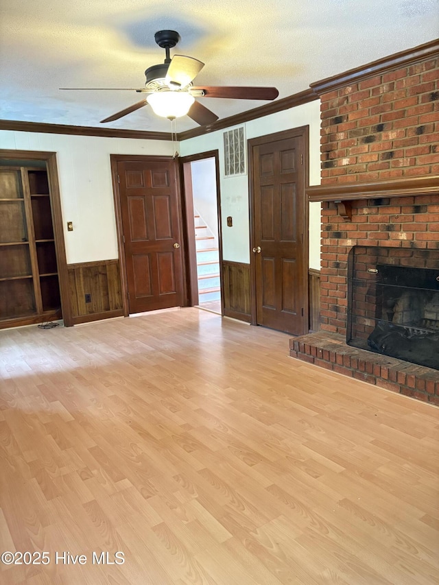 1102 Raleigh Road Parkway W, Wilson, NC 27896 - unfurnished living room featuring crown molding, a ceiling fan, wood walls, wood finished floors, and stairway