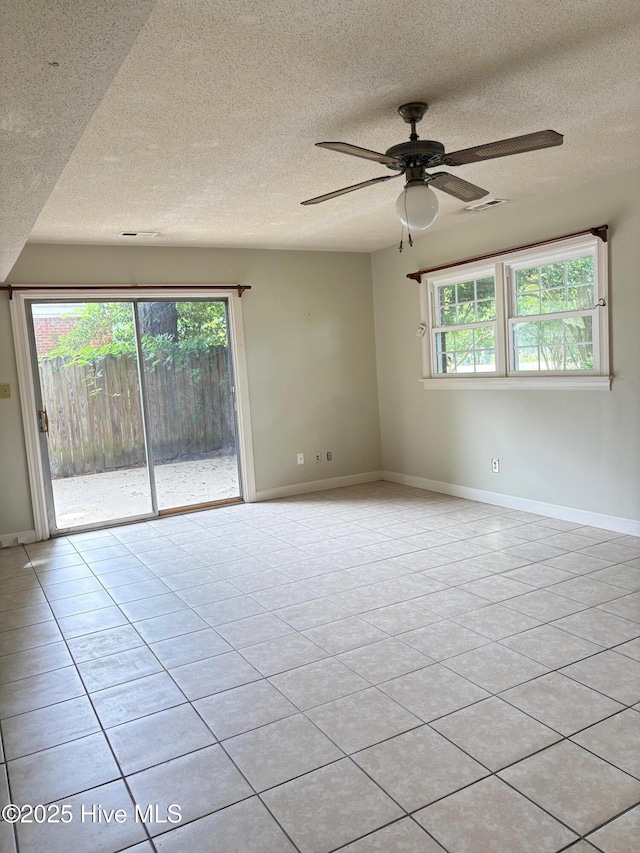 1102 Raleigh Road Parkway W, Wilson, NC 27896 - spare room with plenty of natural light, ceiling fan, a textured ceiling, baseboards, and light tile patterned floors