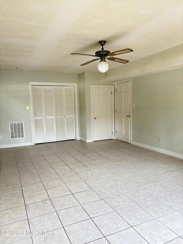 1102 Raleigh Road Parkway W, Wilson, NC 27896 - unfurnished bedroom with a closet, baseboards, a textured ceiling, ceiling fan, and light tile patterned floors