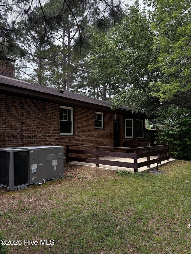 1102 Raleigh Road Parkway W, Wilson, NC 27896 - back of house with central AC unit, brick siding, a wooden deck, and a yard