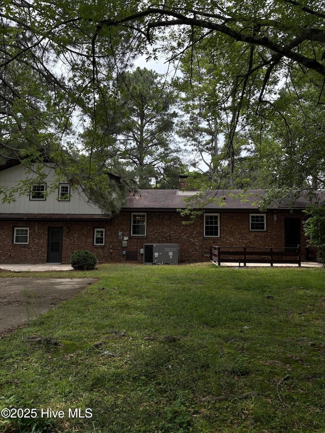1102 Raleigh Road Parkway W, Wilson, NC 27896 - rear view of property featuring a lawn, brick siding, and central air condition unit