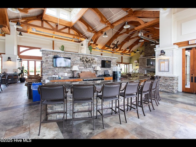 2385 Red Birch Trl NE, Leland, NC 28451 - kitchen featuring high vaulted ceiling, stone tile floors, plenty of natural light, beam ceiling, and dark stone countertops