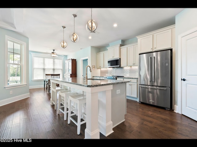 2385 Red Birch Trl NE, Leland, NC 28451 - kitchen with stainless steel appliances, a ceiling fan, a breakfast bar, stone counters, and backsplash