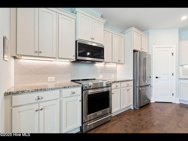 2385 Red Birch Trl NE, Leland, NC 28451 - kitchen featuring stainless steel appliances, tasteful backsplash, white cabinetry, light stone countertops, and dark wood-style flooring