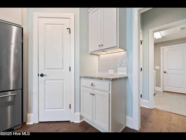 2385 Red Birch Trl NE, Leland, NC 28451 - kitchen with freestanding refrigerator, dark wood-style floors, tasteful backsplash, light stone countertops, and white cabinetry