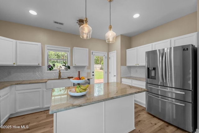433 Shepherd Trl, Aberdeen, NC 28315 - kitchen with stainless steel fridge, a center island, light stone countertops, white cabinetry, and tasteful backsplash