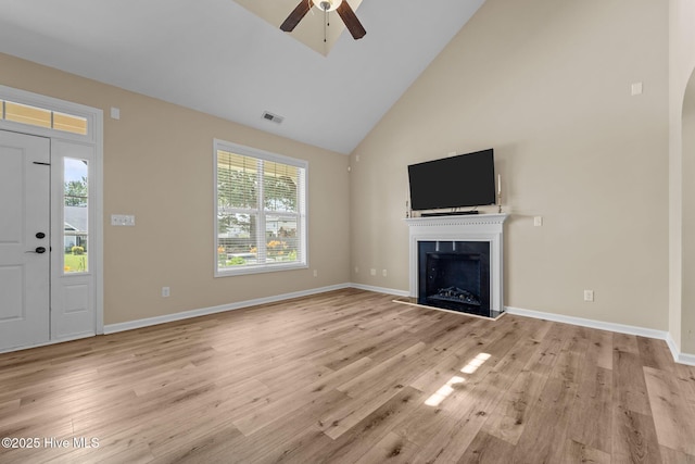 433 Shepherd Trl, Aberdeen, NC 28315 - unfurnished living room with high vaulted ceiling, a ceiling fan, a fireplace with raised hearth, light wood-style floors, and arched walkways
