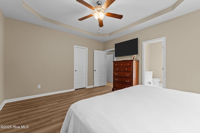 433 Shepherd Trl, Aberdeen, NC 28315 - bedroom with a tray ceiling, wood finished floors, ensuite bathroom, and ceiling fan