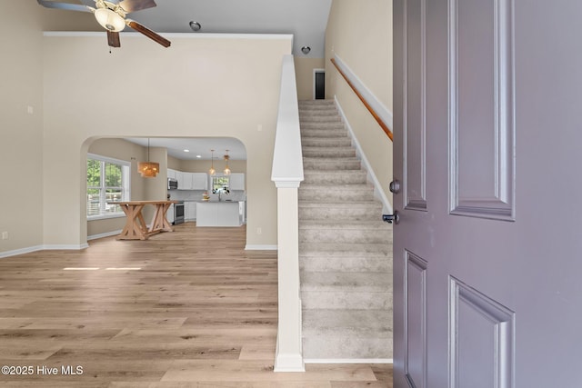 433 Shepherd Trl, Aberdeen, NC 28315 - foyer featuring a ceiling fan, arched walkways, light wood-style floors, stairs, and a high ceiling