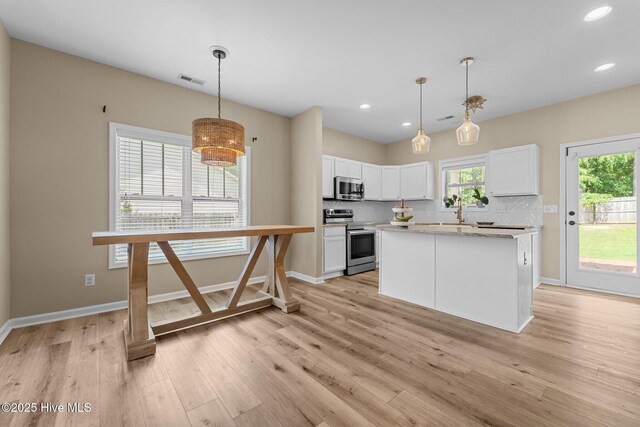 433 Shepherd Trl, Aberdeen, NC 28315 - kitchen with appliances with stainless steel finishes, white cabinetry, healthy amount of natural light, light wood-type flooring, and recessed lighting