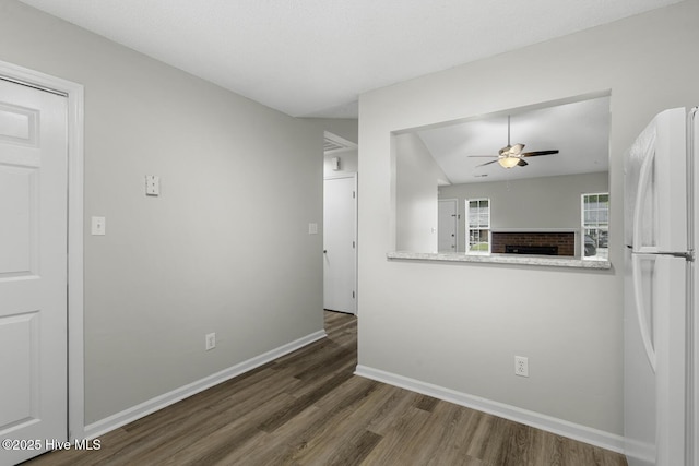 219 Live Oak Ct, Midway Park, NC 28544 - unfurnished living room featuring wood finished floors, a ceiling fan, baseboards, and a brick fireplace